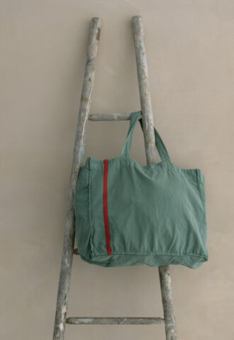 Sac vert sur une échelle ancienne.