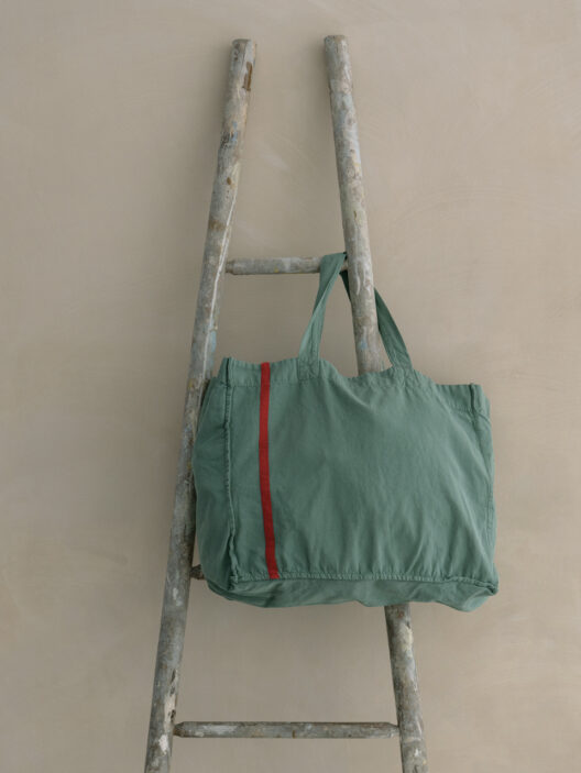 Sac vert sur une échelle ancienne.
