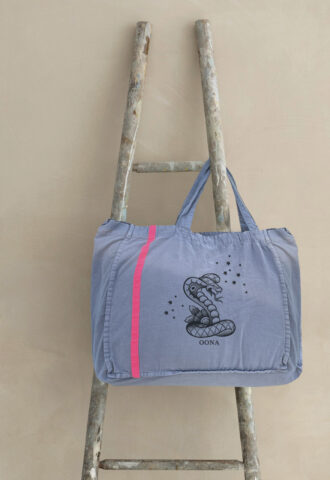 Graue Tasche mit Schlangenmotiv auf Holzleiter