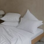 drap housse white 1.jpg Lit avec oreillers et draps blancs.