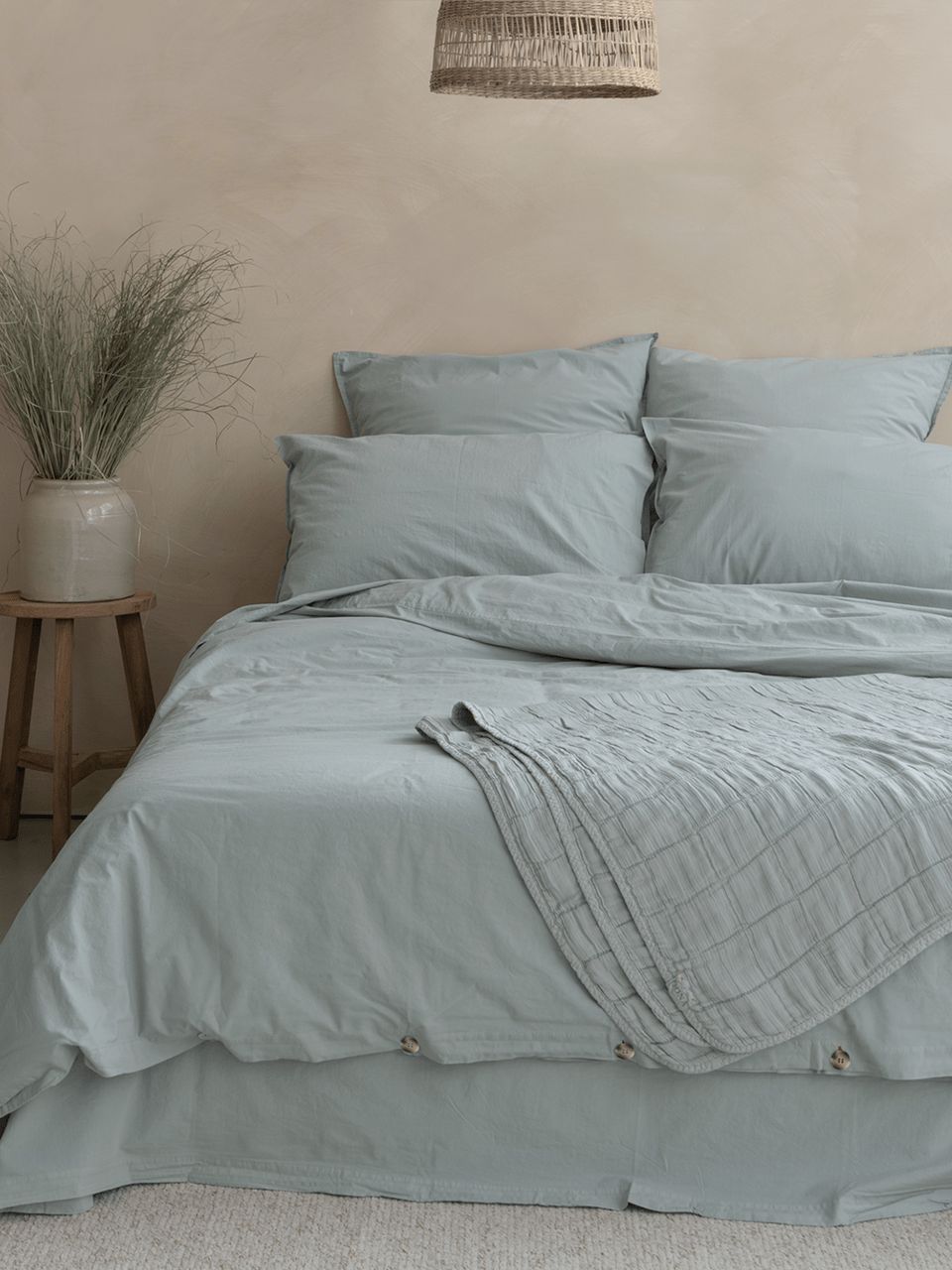 housse couette seafoam 1 1.jpg Lit avec linge bleu dans une chambre apaisante.