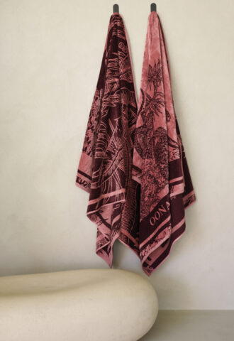 Deux serviettes roses suspendues au mur beige.