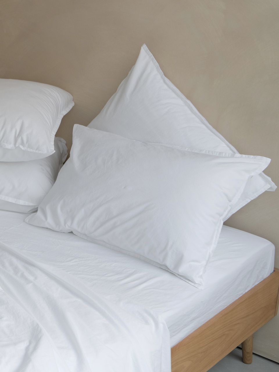 Lit avec draps et oreillers blancs.