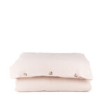 nude housse couette Housse de couette beige avec boutons visibles.