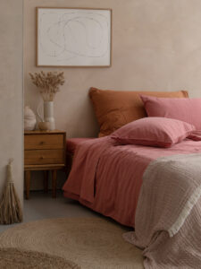 Chambre avec décoration minimaliste et literie rose.