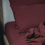 Literie en lin bordeaux sur un lit.