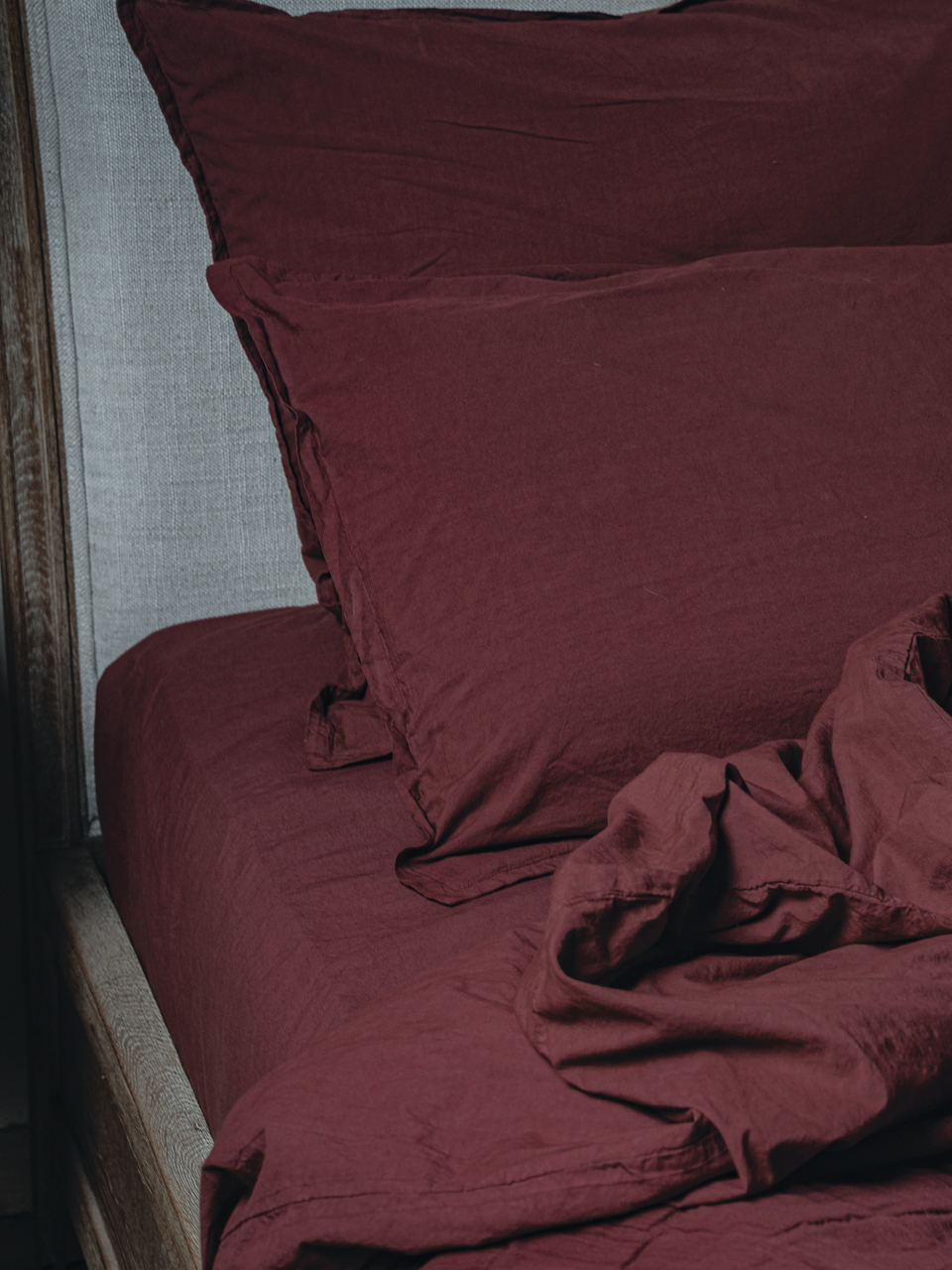 Literie en lin bordeaux sur un lit.