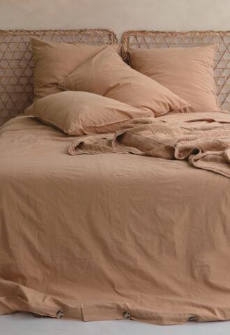 Lit avec couvre-lit beige et oreillers