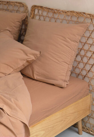 Lit beige avec tête de lit en rotin