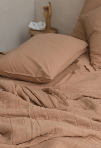 Lit avec draps beiges et décor simple