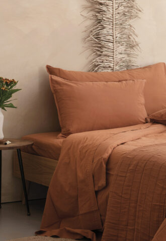 Lit avec linge de lit terracotta chaleureux