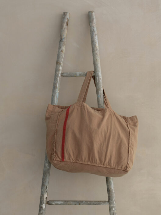 Sac cabas beige suspendu à une échelle