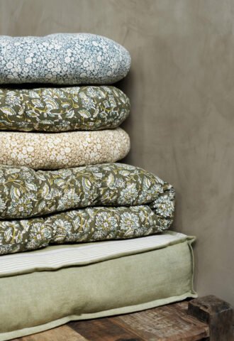 Pile de coussins et couettes à motifs floraux verts
