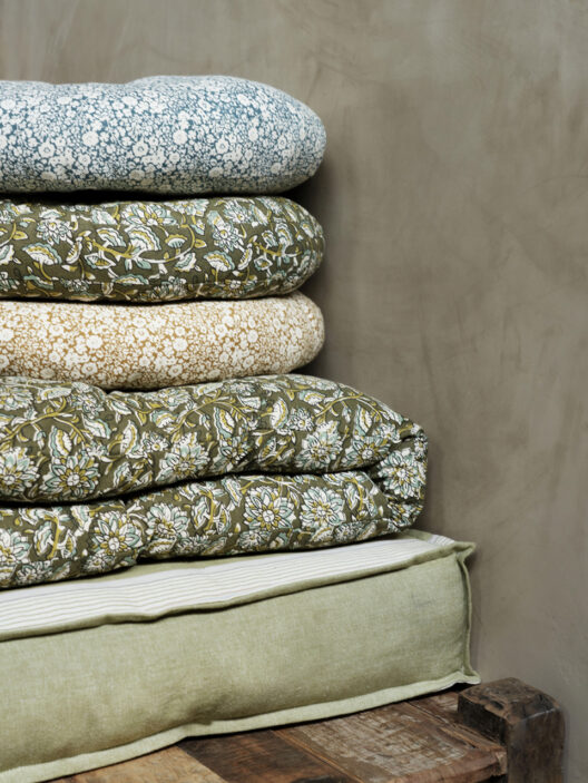 Pile de coussins et couettes à motifs floraux verts